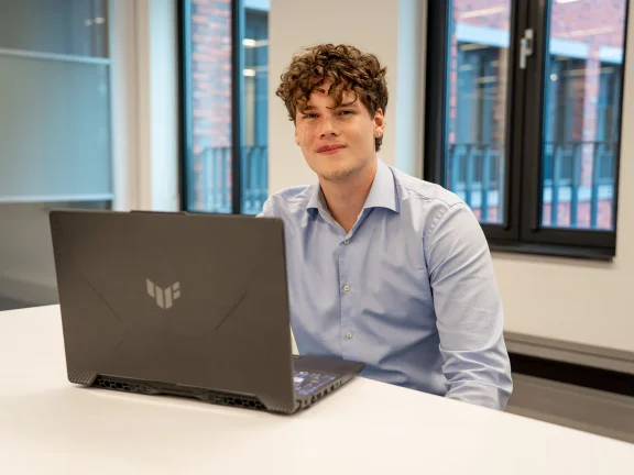 Jack van der Vall achter zijn laptop, kijkend naar de camera